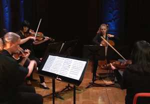 Four musicians playing. Photo.