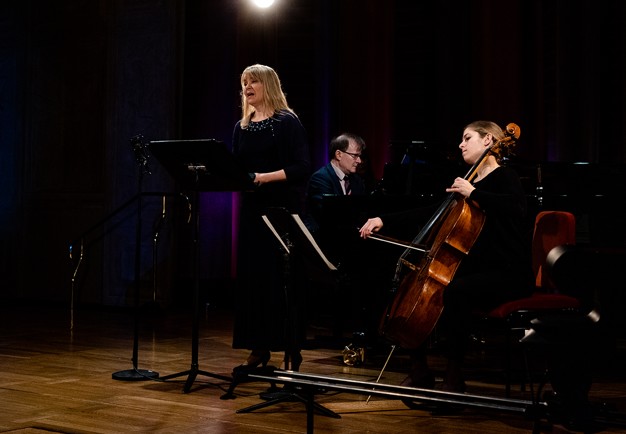 En sångerksa, en cellist, en pianist. Fotografi.