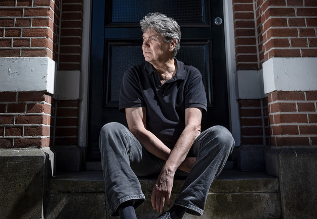 Man som sitter på en trappa. Fotografi.